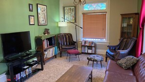 Un salon équipé d’un téléviseur, de bibliothèques, d’une table basse et de meubles en cuir.