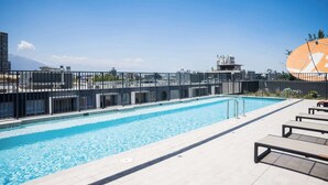 A rooftop swimming pool with a clear view of the city skyline and mountains in the background. - Best of Providencia Modern 2BR Steps from Metro (Providencia)