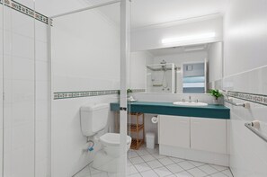 A modern bathroom with a toilet, sink, and shower.