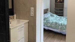 A bedroom with a bed, a bedside table, a nightstand, and a wardrobe. - Apartment Le Pellerin (Le Pellerin)