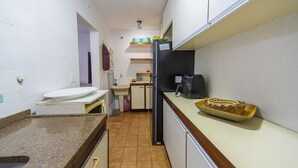 A compact kitchen with a sink, countertop, and a refrigerator. - Apto c Piscina Garagem e Academia a 180m da Praia (Guarujá)