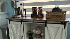 A kitchen with a coffee machine, jars, and a potted plant on the counter. - Casa Brilliance Key Largo Retreat – Family-Friendly 3BR Island Getaway (Key Largo)