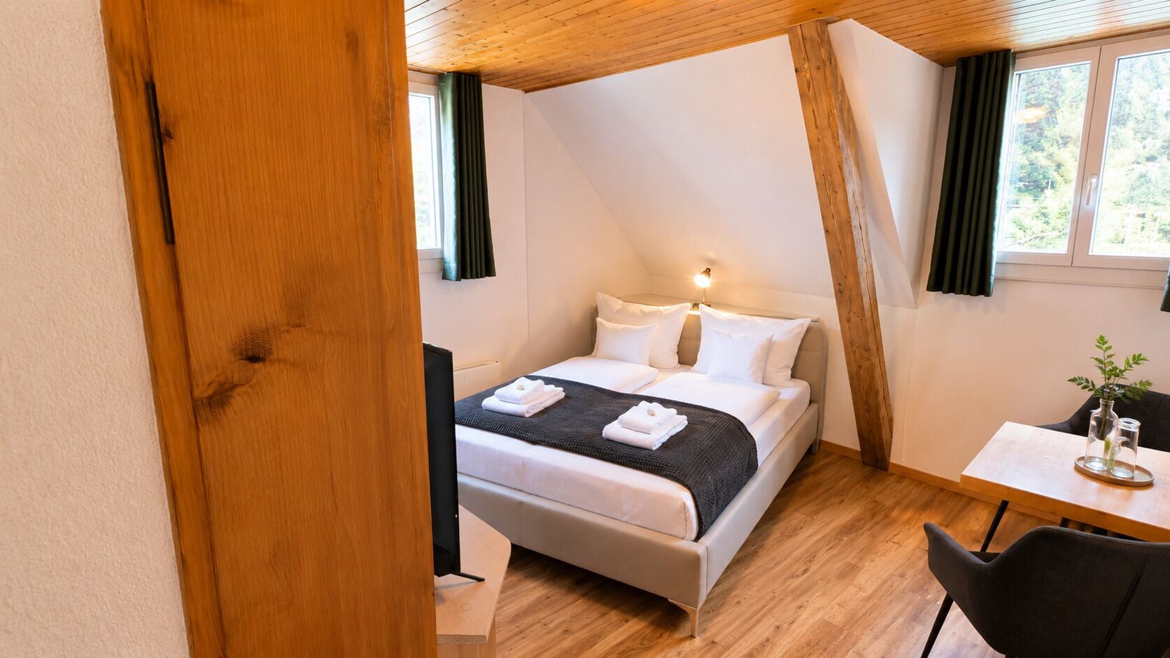 Un dormitorio con cama, mesita de noche y ventana.