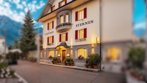 A hotel named "GASTHOF STERNEN" with a traditional European architectural style, featuring a balcony and multiple windows with red shutters. - Hotel Sternen Gurtnellen (Gurtnellen)