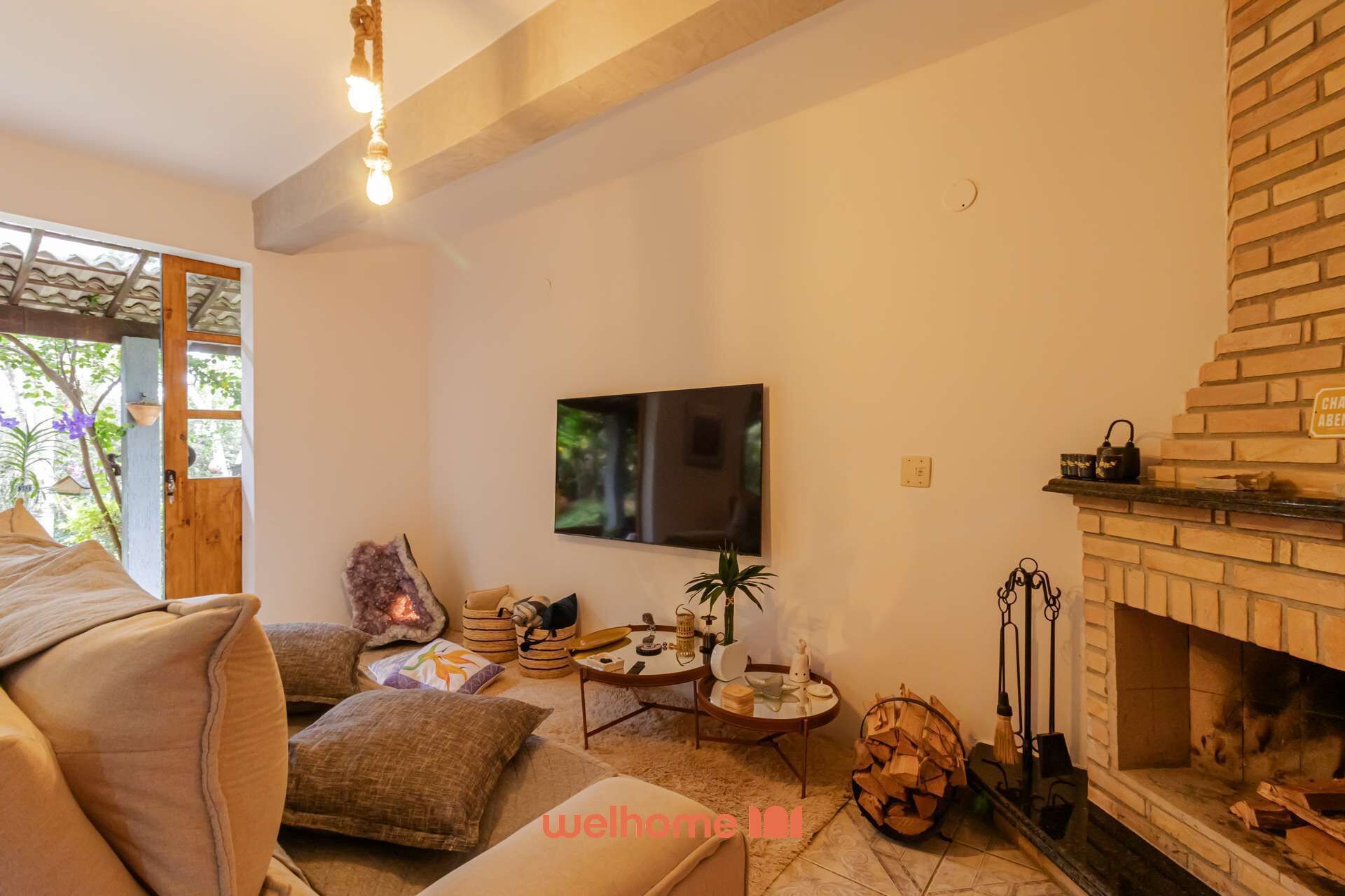 A cozy living room with a fireplace, a television mounted on the wall, and a comfortable sofa.