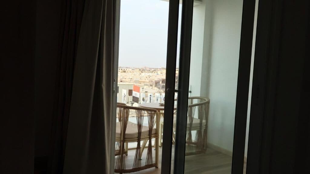 Een balkon met uitzicht op een stadsgezicht.
