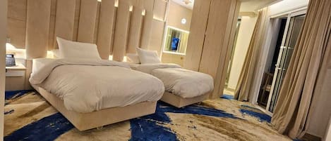 Une chambre d’hôtel moderne dotée d’un grand lit, d’un canapé séparé, d’une grande fenêtre et offrant une vue sur la ville.