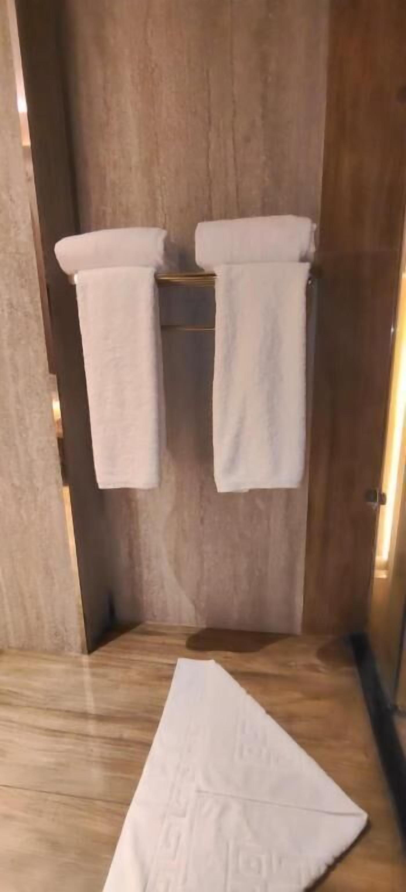 Ein Zimmer aus Holz mit zwei Handtüchern an einem Wäscheständer und einem Handtuch auf dem Boden.