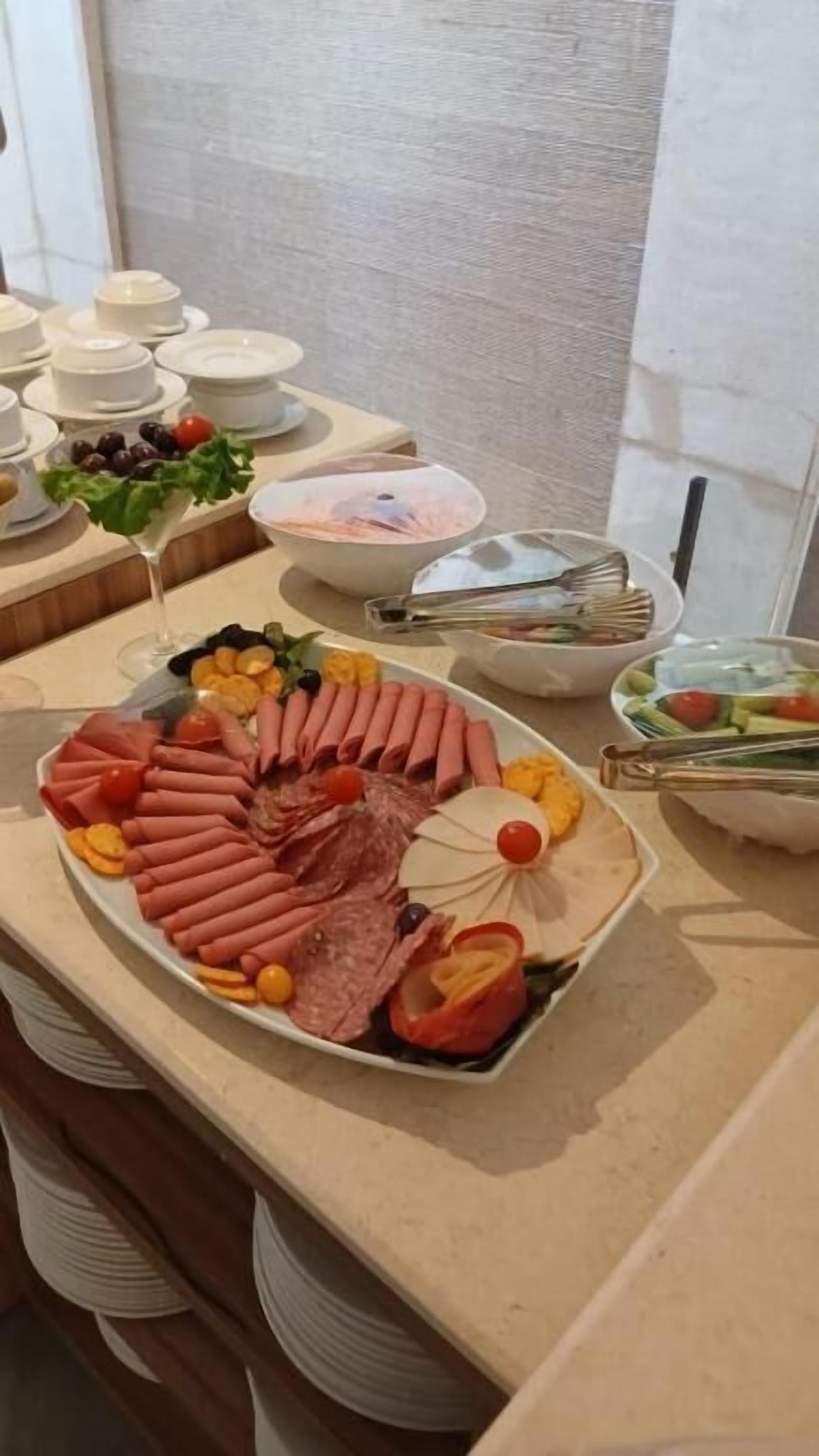 Un buffet proposant une variété de plats, notamment des viandes, des fromages et des légumes.