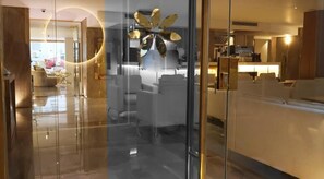 A modern interior with a glass partition, a central light fixture, and a seating area with sofas. - Flamingo hotels & tours (Cairo)
