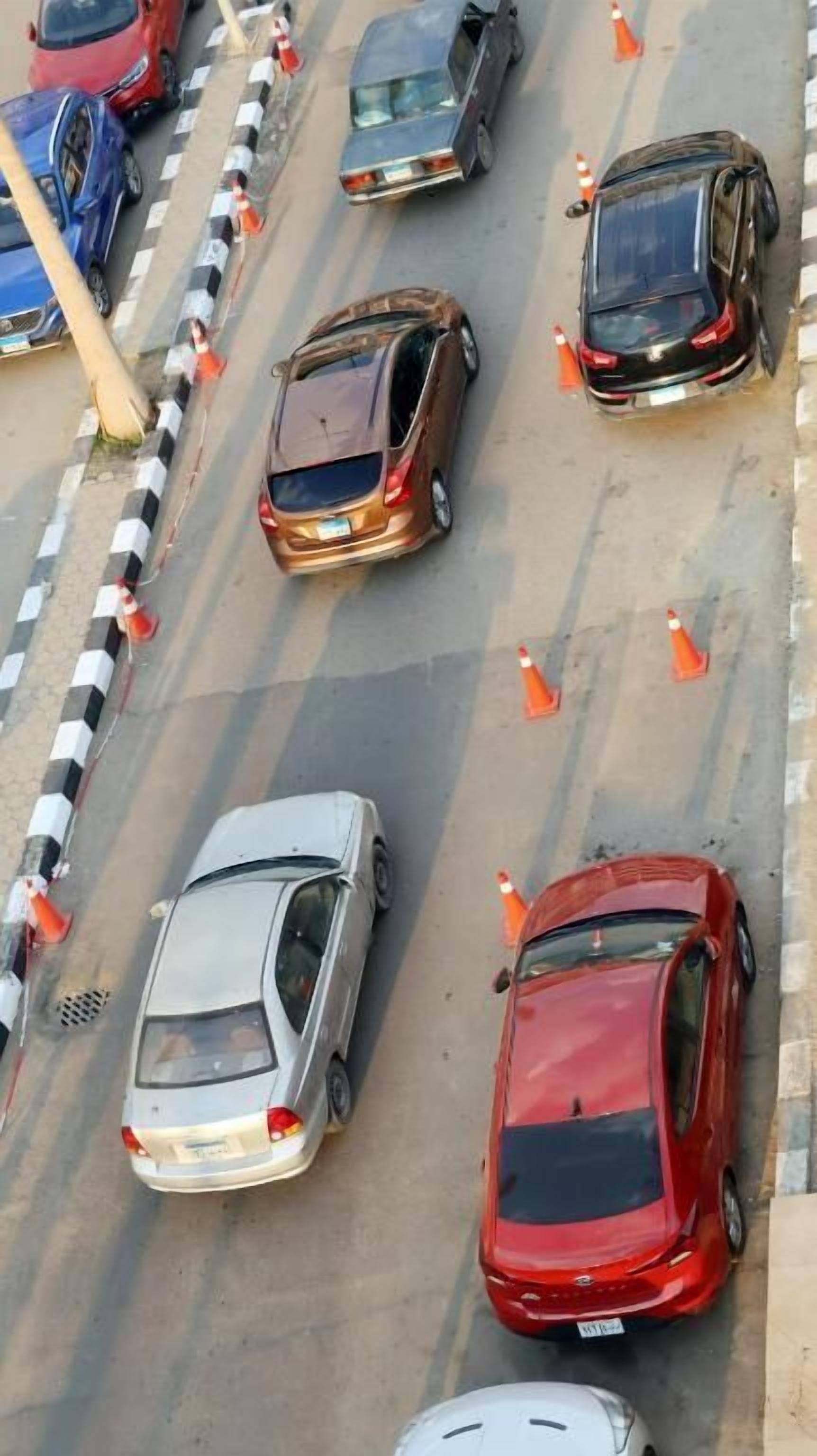A multi-lane road with vehicles and traffic cones.
