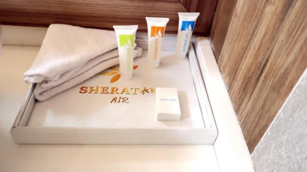 A tray with toiletries including a towel, a hair product, and a soap bar.