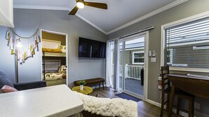 A compact living space with a kitchenette, a dining area, a sofa, a ceiling fan, and a view through a sliding glass door to an outdoor deck. - 2 Bed/2 Bath - Pet Friendly, Sleeps 6 - 2 Bed/2 Bath - Pet Friendly, Sleeps 6 (Glen Saint Mary)