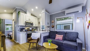 A modern kitchen with white cabinets, a central island, and a dining area with a wooden table and chairs. - 2 Bed/2 Bath - Pet Friendly, Sleeps 6 - 2 Bed/2 Bath - Pet Friendly, Sleeps 6 (Glen Saint Mary)