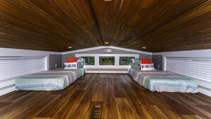 Ein Schlafzimmer mit zwei Betten, einem Oberlicht und Blick ins Freie.