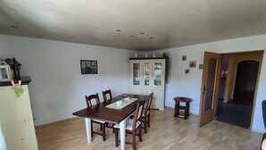 A dining area with a wooden table, chairs, a cabinet, and a small side table. - Eichweg vacation apartment (Bad Sooden-Allendorf)