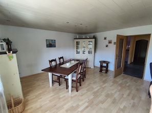 A dining area with a wooden table, chairs, a cabinet, and a small side table.