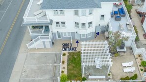 A two-story building with a covered entrance labeled "SURF 3 ENTRANCE". - Surf 3 - Steps to beach and OC Boardwalk (Ocean City)