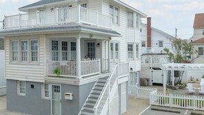 A two-story house with a balcony, a covered porch, and a garage. - Surf 1 - Steps to the beach and boardwalk (Ocean City)