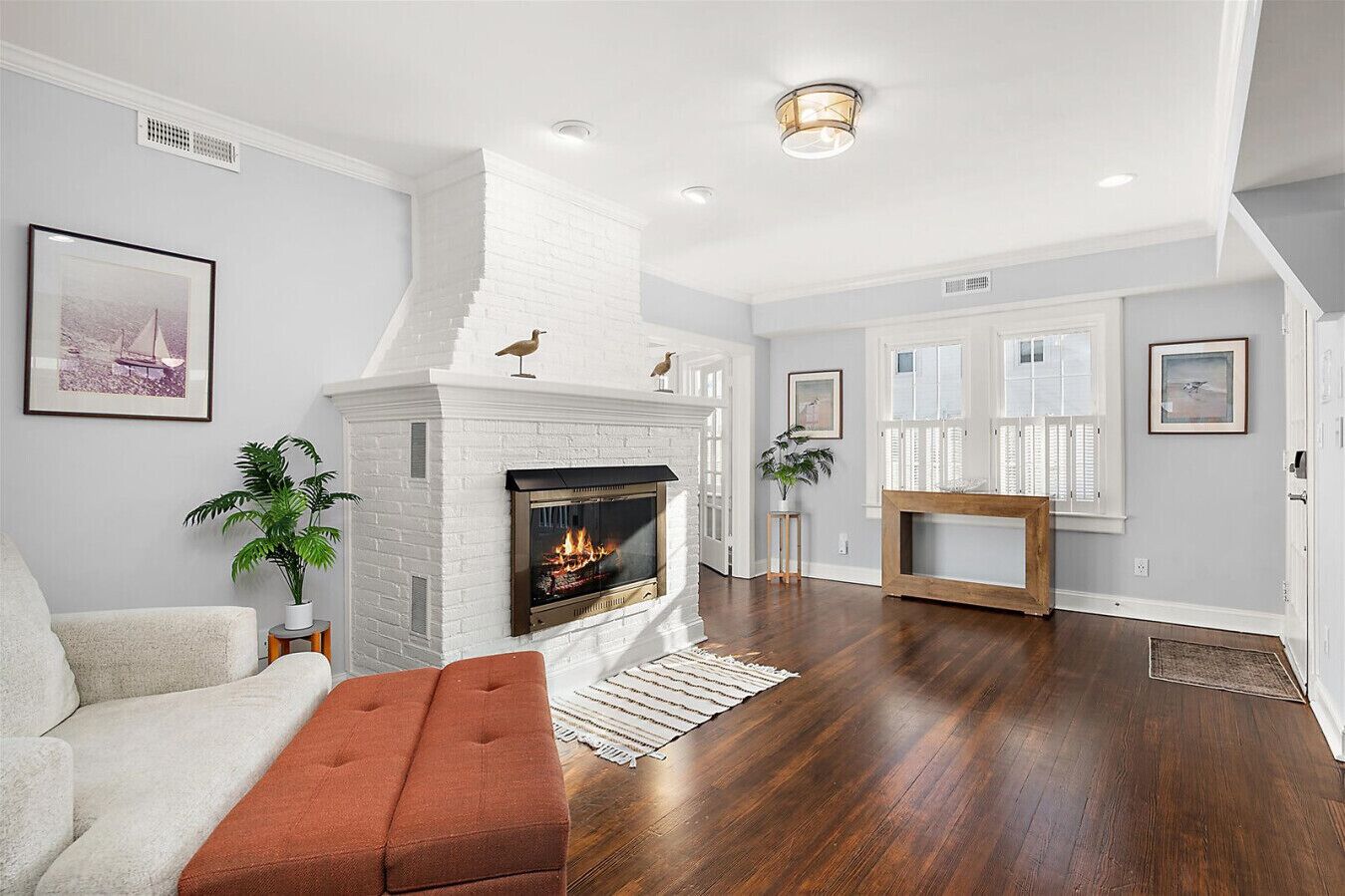 Un salon avec une cheminée, un canapé, une table basse et une console en bois.
