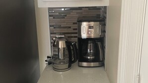 Eine Küche mit Kaffeemaschine, Wasserkocher und Mikrowelle.