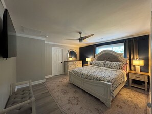 A bedroom with a bed, bedside tables, a ceiling fan, a window, and a door. - 7 Min to HPU • Private Gym • Game Room • Fire Pit • Sleeps 9 (High Point)