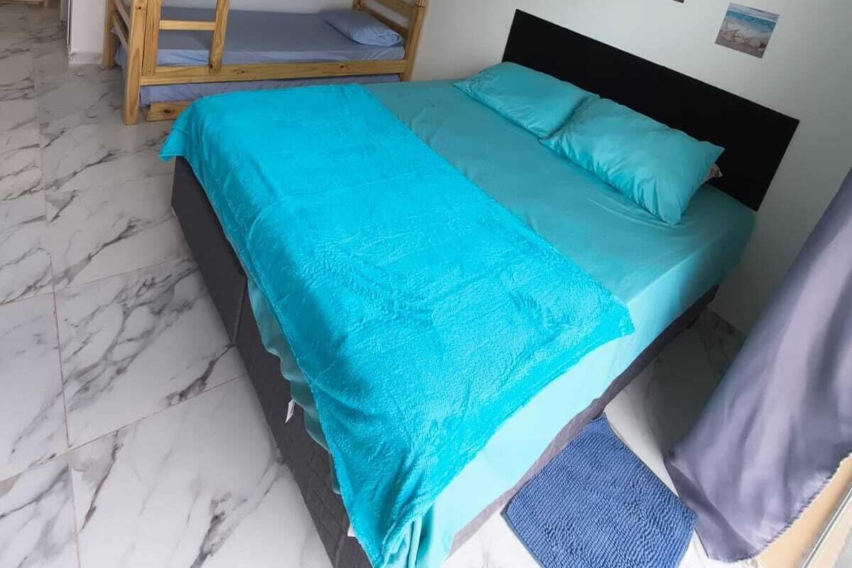 A bedroom with a bunk bed, a single bed, and a ceiling light fixture.