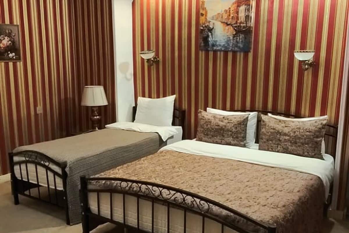 Superior driepersoonskamer | Luxe beddengoed, een kluis op de kamer, een bureau, een laptopwerkplek