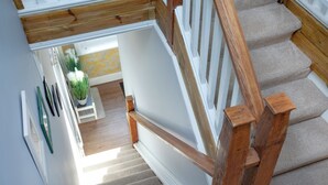 Eine Treppe mit Holzgeländern und beige getönten Teppichstufen.