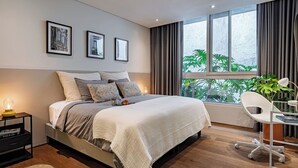 Una camera da letto moderna con un letto grande, una scrivania con una sedia e una finestra con tende.