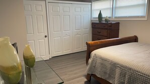A bedroom with a bed, dresser, and two doors. - 3-bedroom 2 BA Coastal Ranch house New Castle with long driveway (Wilmington Manor)