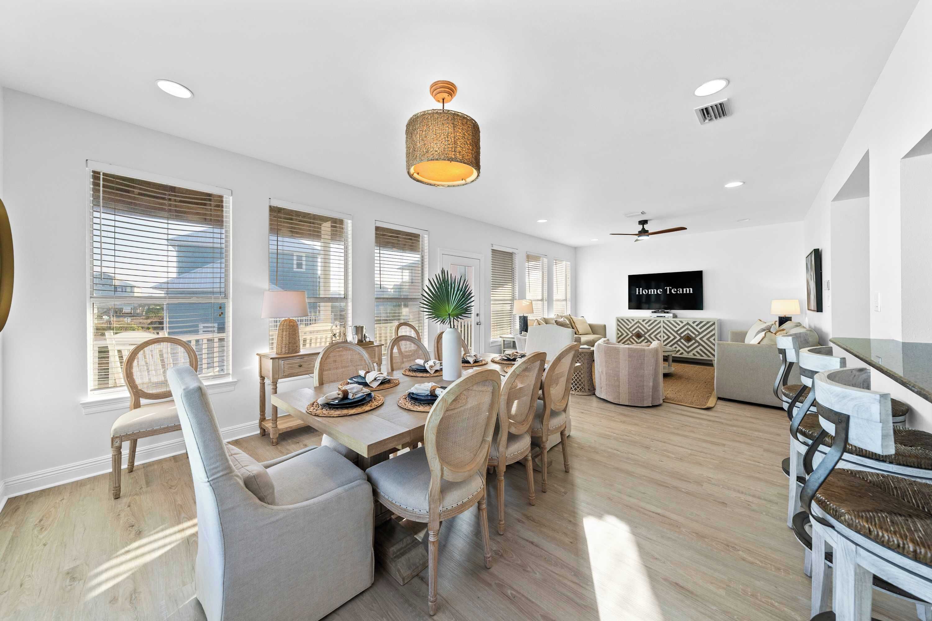 A modern dining area with a wooden table, chairs, and a hanging light fixture.