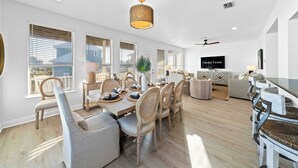 Un comedor moderno con una mesa de madera, sillas y una lámpara colgante.