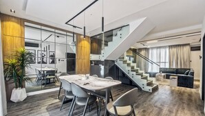 Un intérieur moderne comprenant un coin repas, un escalier et un espace de vie.