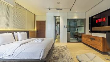 A modern bedroom with a large bed, a TV, and a wooden cabinet.