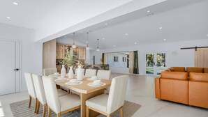 Een moderne eetruimte met een houten tafel voor zes personen, omringd door witte stoelen.