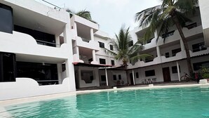 Ein Swimmingpool mit einem weißen Gebäude im Hintergrund.