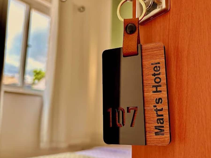 A wooden door with a room number sign and a keychain.
