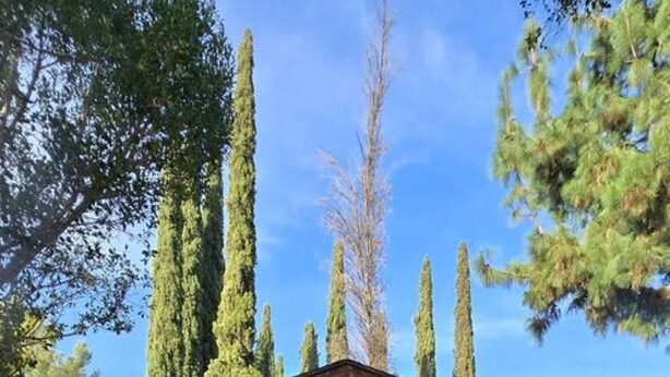 A small, single-story house with a white exterior and a brown roof. It features a front door with a window above it, a small porch with two wicker chairs, and a well-maintained lawn. - Cozy house+close to Glendale,Pasadena,DT & K-Town (La Crescenta-Montrose)