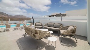 A rooftop terrace with a pool, wicker furniture, and a clear view of the mountains. - Luxury, High-Standard Villa with Hot Tubs, Air Con & Pool - Sleeps 8 (Playa Blanca)