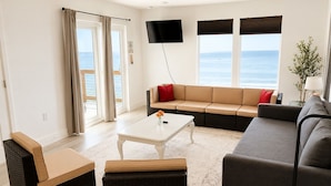 Ein modernes Wohnzimmer mit einer Couch, einem Couchtisch und einem Fernseher.