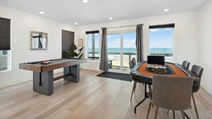 Ein Raum mit Billardtisch, Blackjack-Tisch und Meerblick.