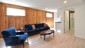 Un salon avec un canapé bleu, un fauteuil bleu et une table basse en bois.