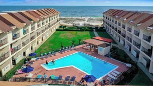 Ein Hotel mit Schwimmbad, Blick auf den Strand und mehreren Balkonen.