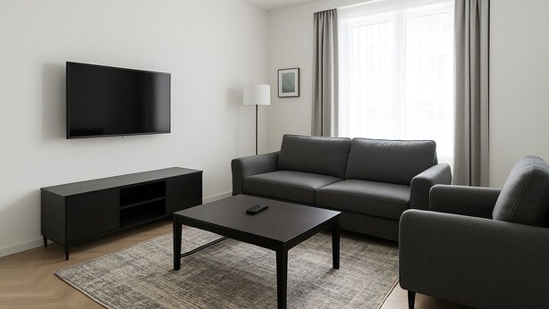 A modern living room with a flat-screen TV, a grey sofa, a coffee table, and a floor lamp. - CJ Apartment  (Kasoa)