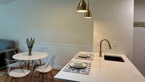 Una cocina moderna con encimera blanca, pileta integrada y ventilador de techo.