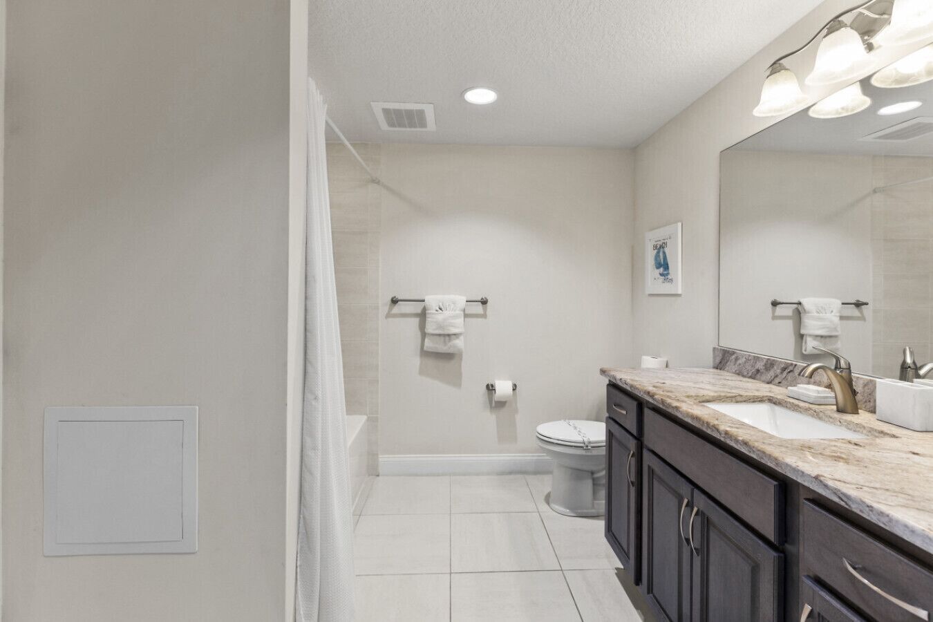 A modern bathroom with a shower, toilet, and vanity.