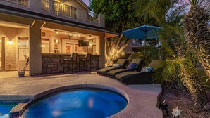 A pool area with a bar, lounge chairs, and a covered seating area. - Family Fun in Ahwatukee Phoenix (Phoenix)