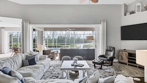 A spacious living room with a large window, a sofa, a coffee table, and a TV. - Rvc1435 (Punta Gorda)