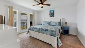 A bedroom with a bed, a nightstand, a ceiling fan, and a view of the outdoors. - Port Charlotte Private Waterfront Condo Wa4410-317 (Port Charlotte)